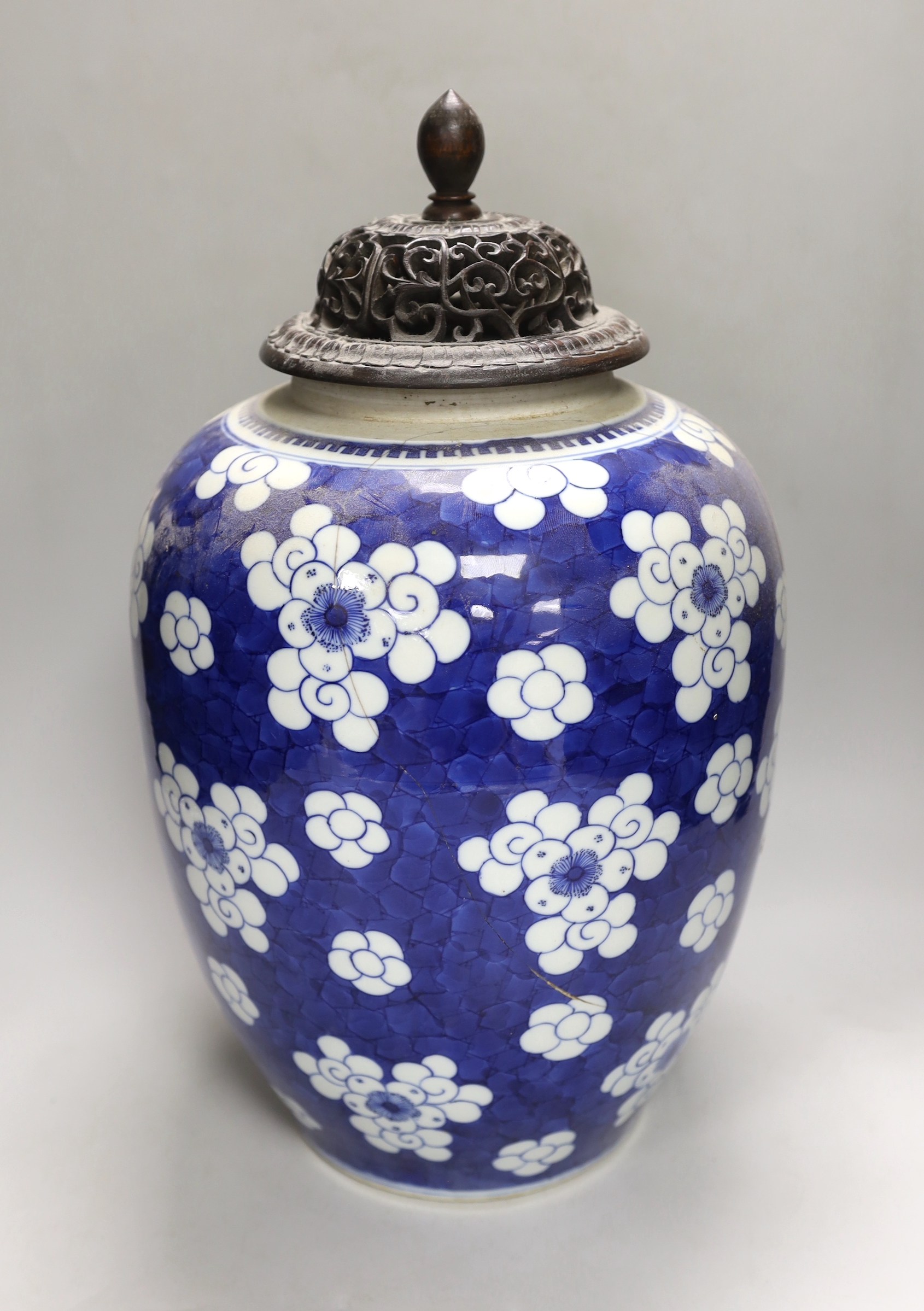 A large Chinese blue and white prunus pattern vase, with carved hardwood cover, 42cm (a.f.)